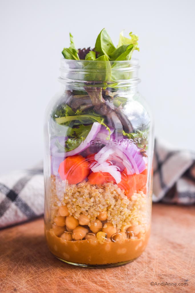 nourish mason jar salad on cutting board with kitchen towel in background