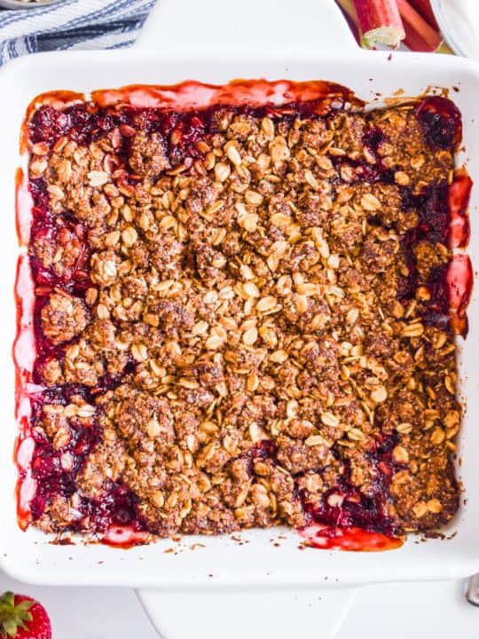 close up detail of strawberry rhubarb crisp in white baking dish