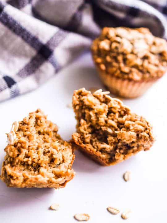 banana oatmeal muffin broken in half. A full muffin behind it.
