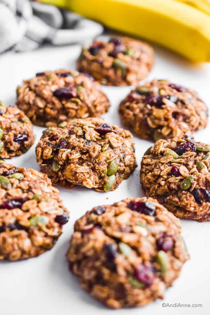 banana cranberry breakfast cookies on white table with bananas in the background
