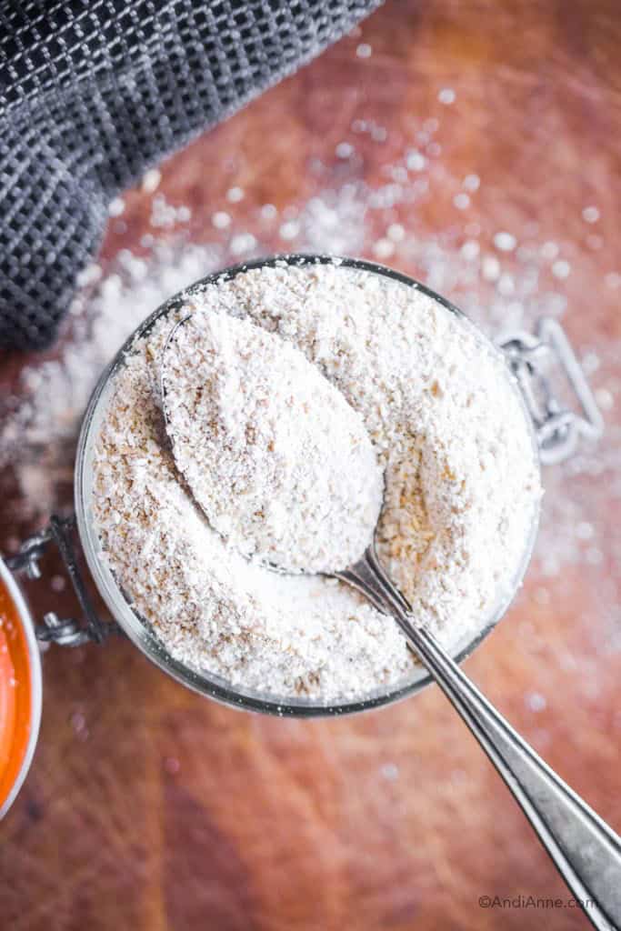 detail look at oat flour in a jar with a spoon on top