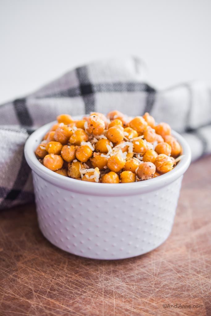 roasted parmesan chickpeas piled in a white bowl with a kitchen towel in the background