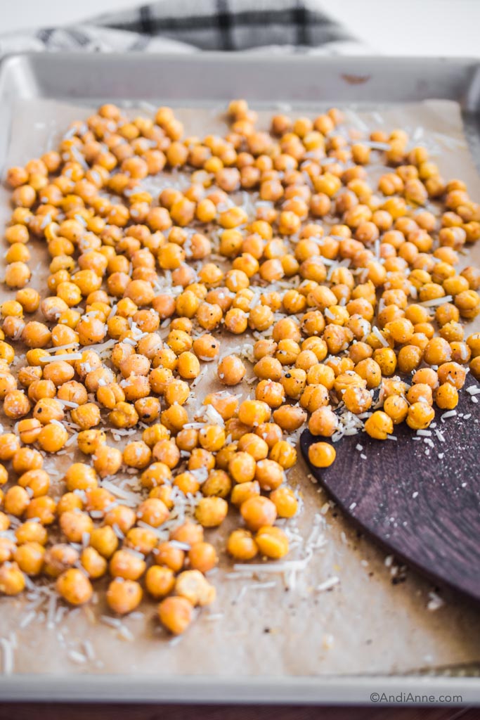 roasted chickpeas on a baking sheet with a wood spatula