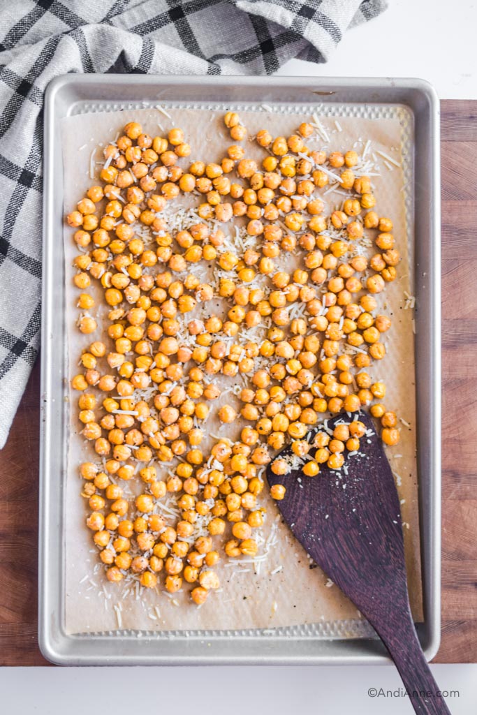 roasted parmesan chickpeas on a baking sheet with wooden spatula.