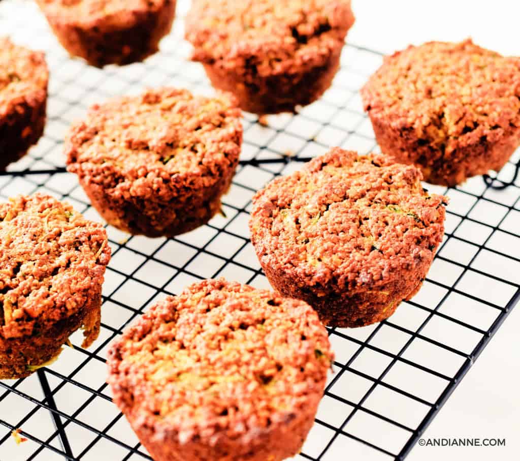 zucchini orange oat muffins on a black cooling rack