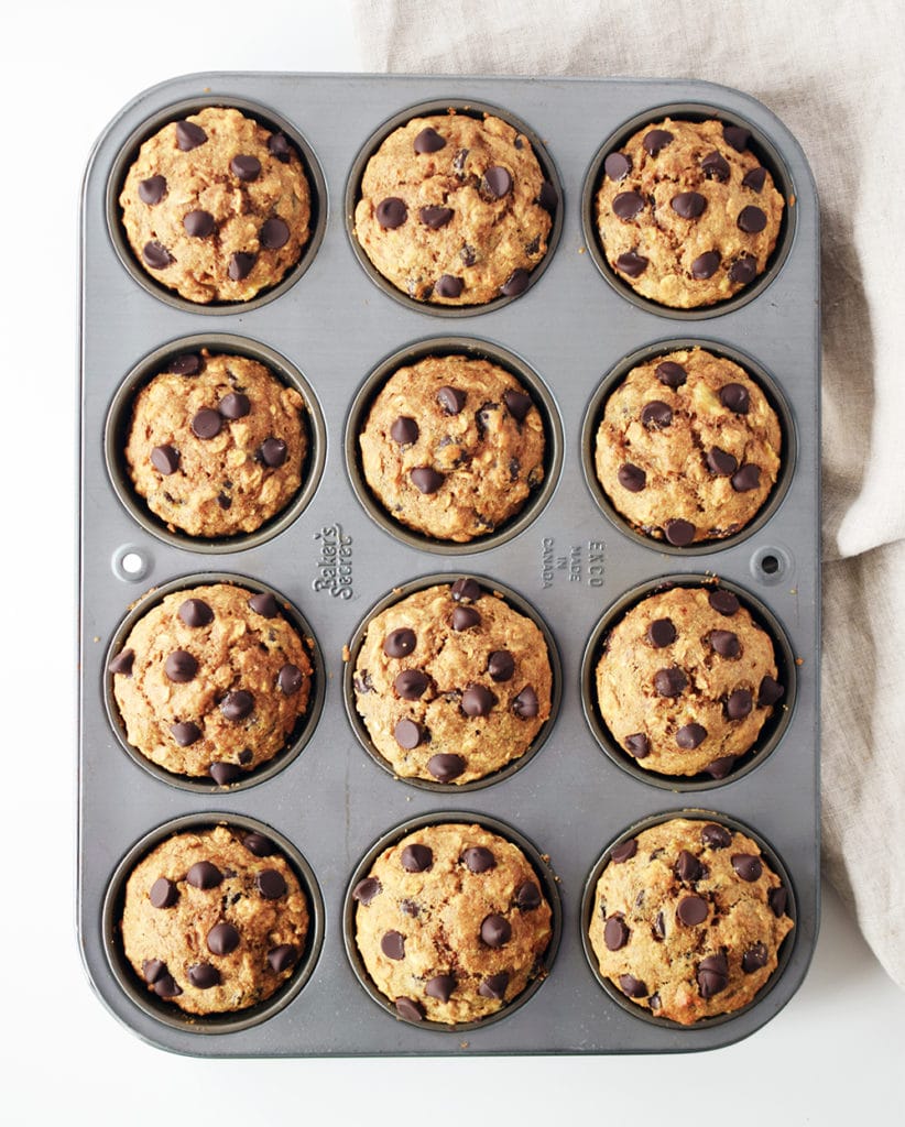spelt muffins in baking pan with beige napkin beside
