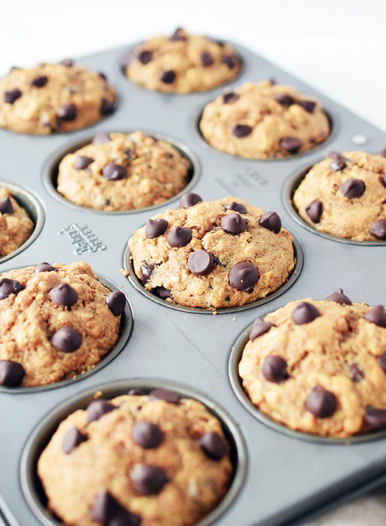 angled view of spelt muffins in muffin pan. Close up detail of chocolate chips on top