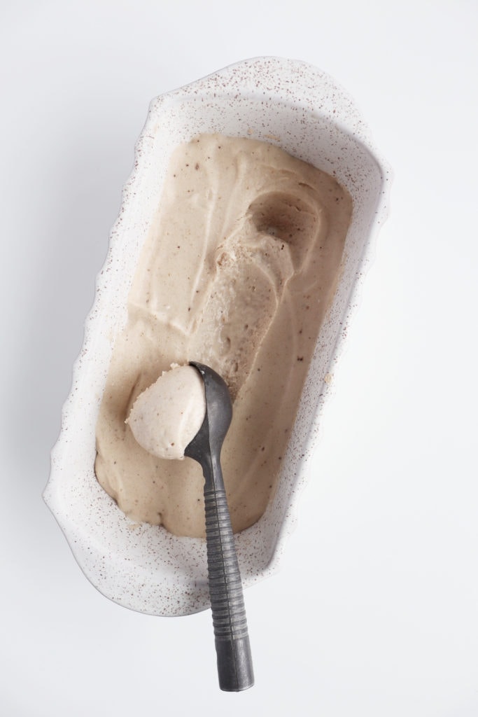 banana nice cream in a ceramic loaf pan with ice cream scooper