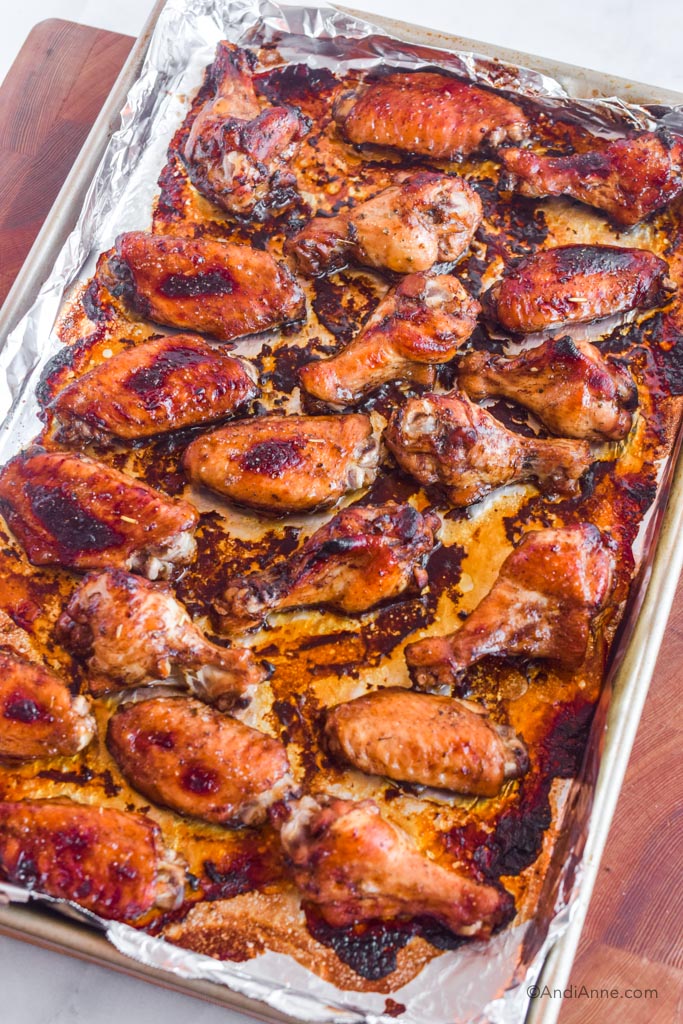 Baked chicken wings on a baking sheet with aluminum foil.