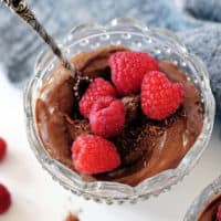 chocolate avocado mousse in glass bowl with fresh berries on top