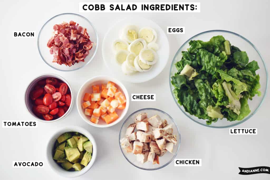 cobb salad ingredients in separate glass and white bowls beside eachother