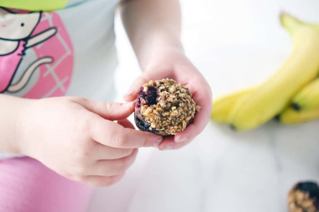 toddler hands holding oat berry muffins