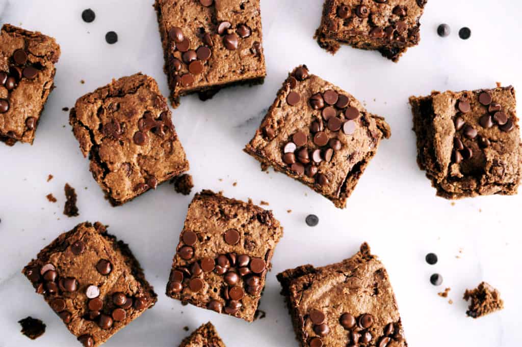 nut butter oat brownies in squares spread out on white marble counter