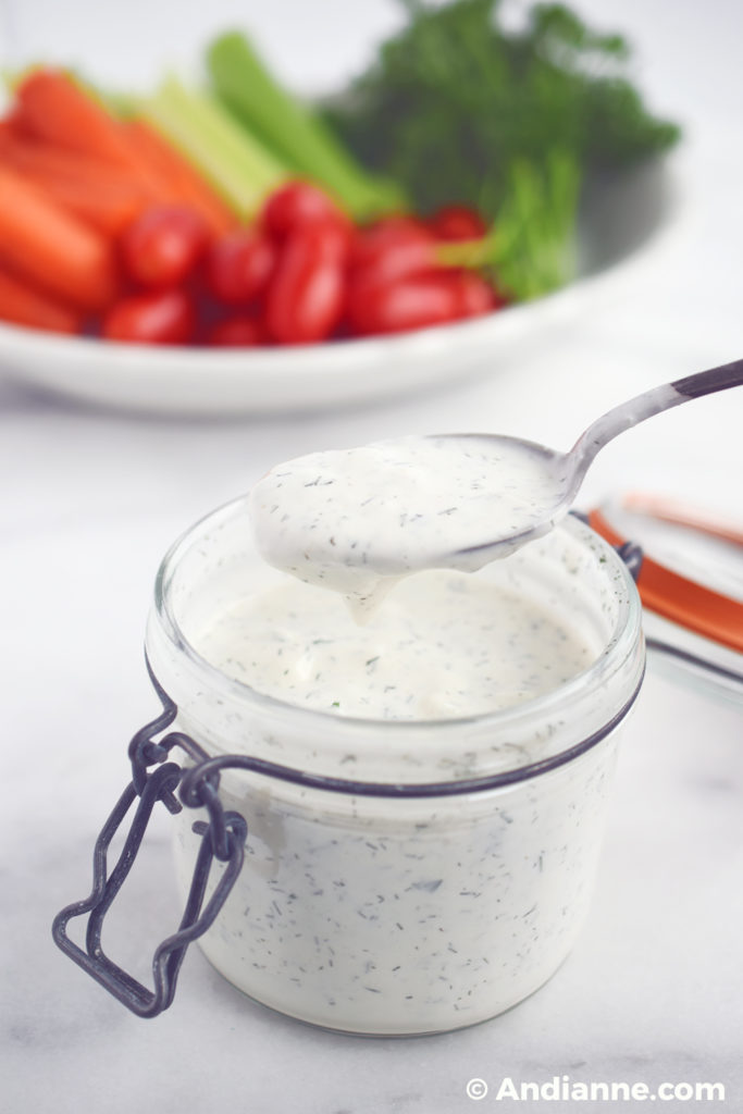 homemade buttermilk ranch dressing in a jar with vegetables in backround