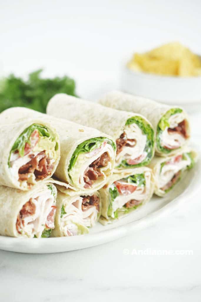 chicken bacon ranch wraps on a plate with parsley and tortilla chips in background