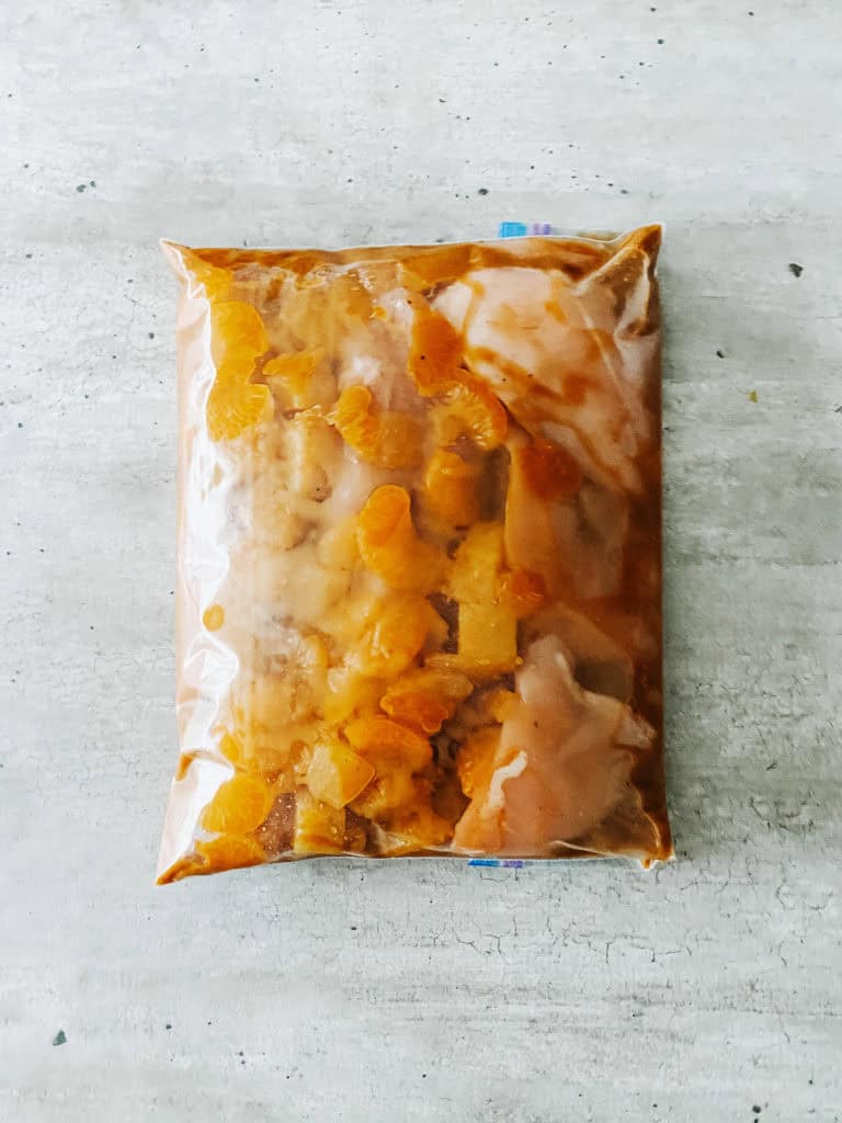 sealed freezer bag with recipe ingredients inside on counter.
