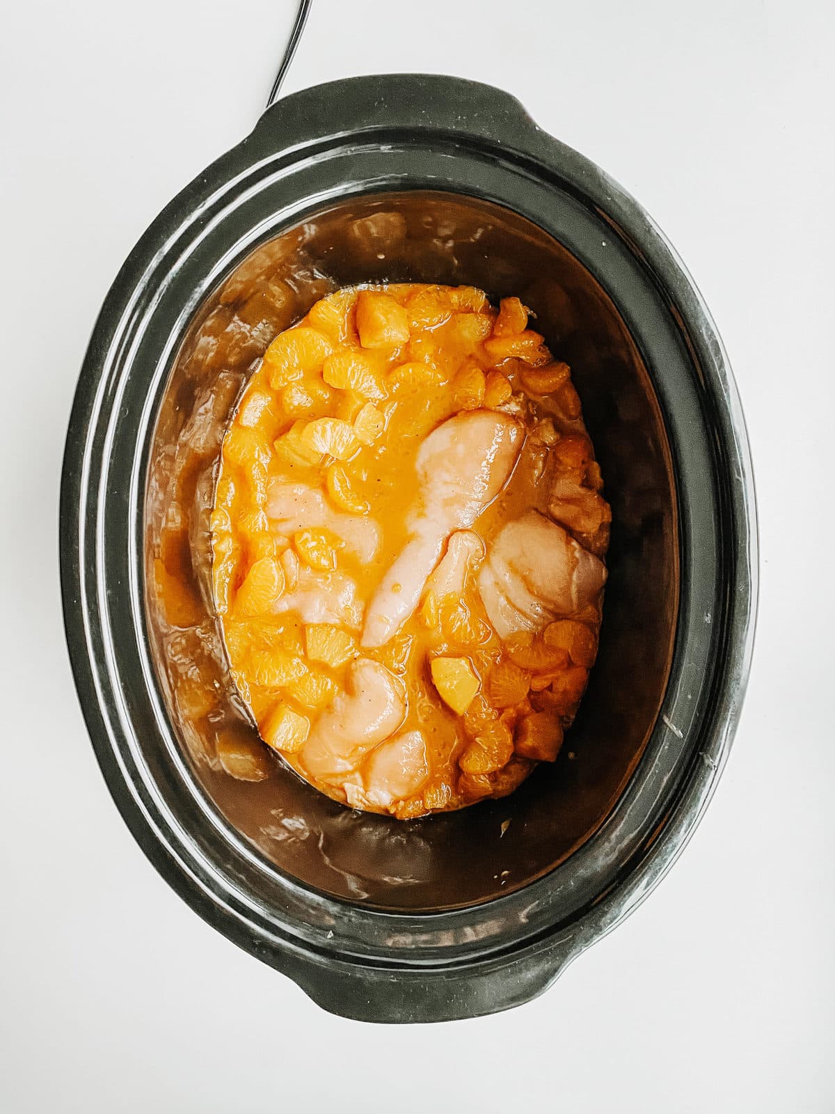 pineapple orange chicken ingredients all poured into slow cooker