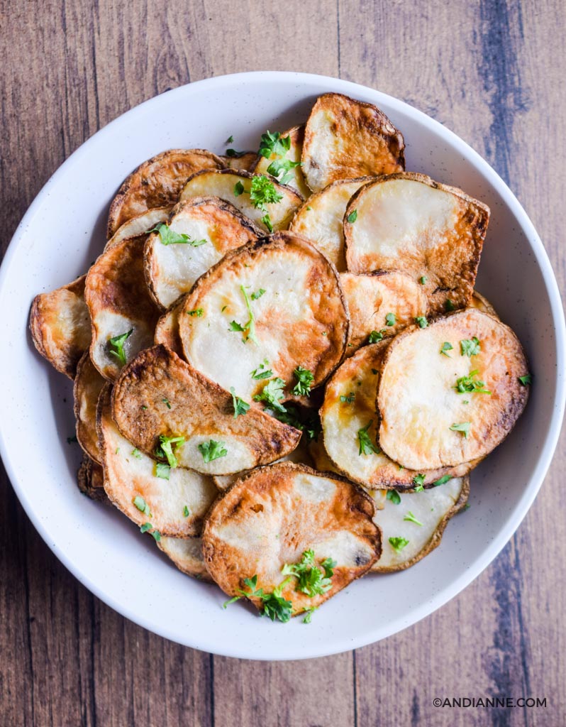 air fryer potato chips in a white bowl with wood background