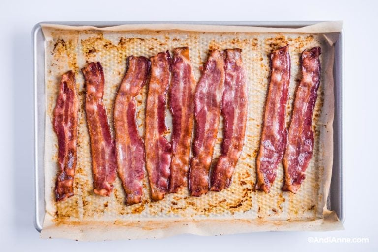 cooked bacon on a baking sheet with parchment paper