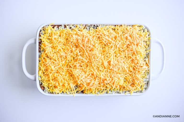 shredded cheddar cheese layer on top of white casserole dish