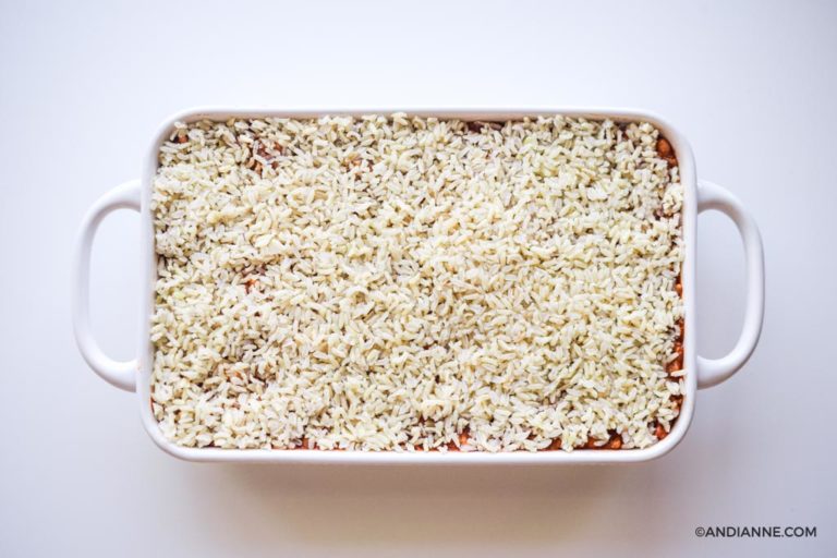 rice on top of ground beef mixture in white casserole dish