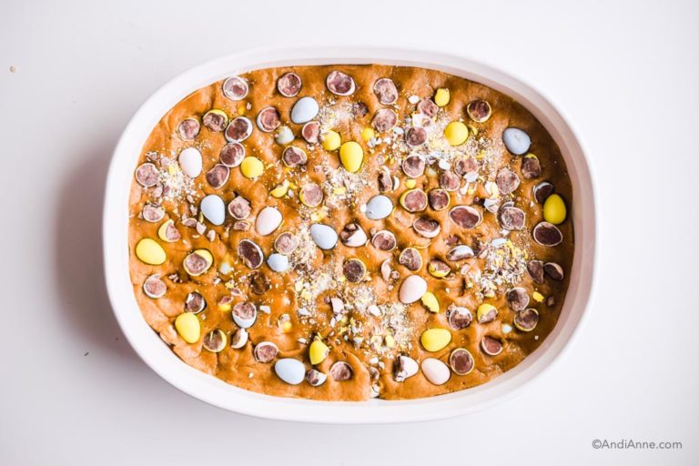 raw batter pressed into white oval dish with crushed cadbury mini eggs on top