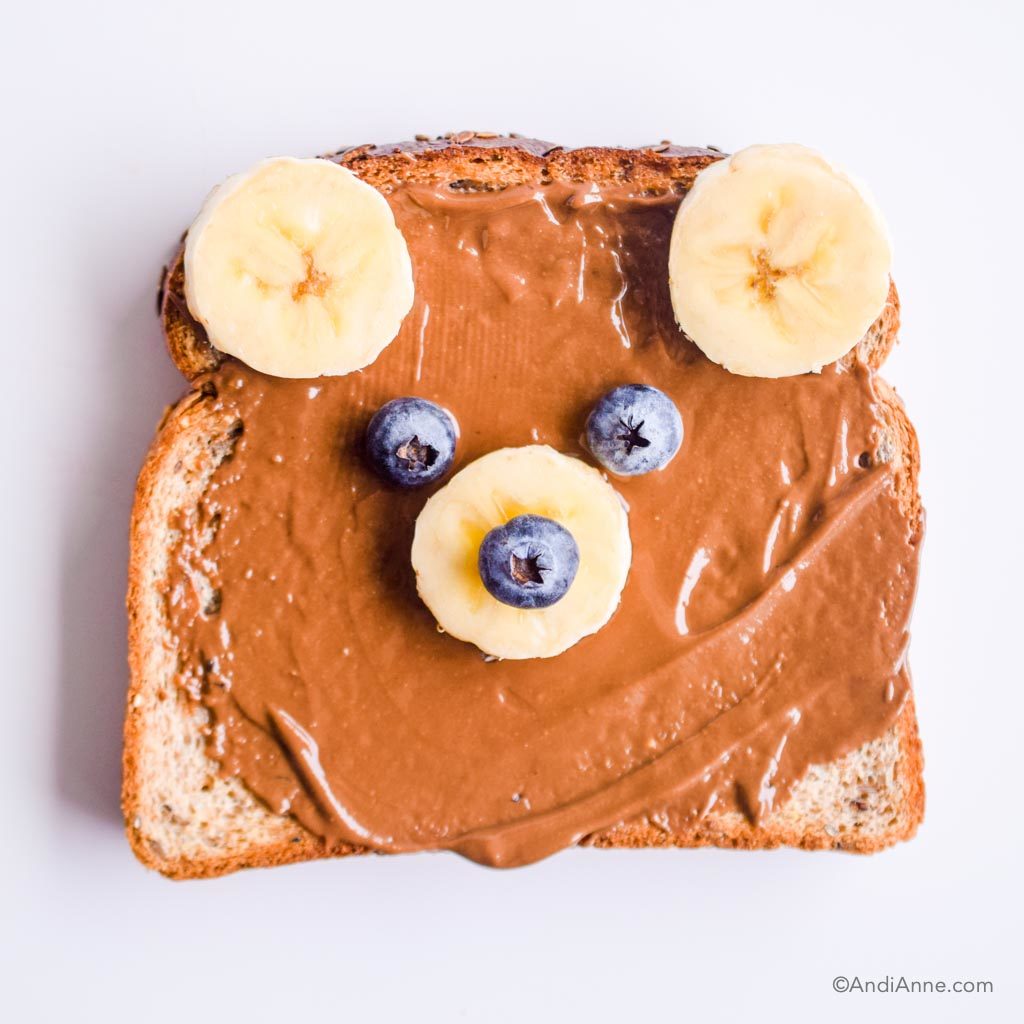 bear toast with chocolate nut butter spread, bananas and berries to make bear face