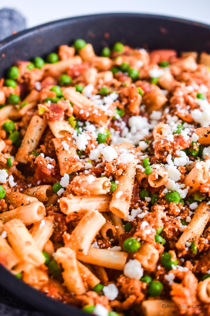 close up of rigatoni ground chicken and peas sprinkled with feta cheese