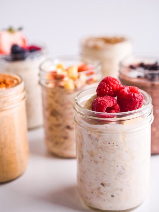 close up detail of raspberries on top of mason jar with oats inside