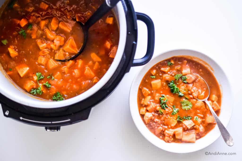 sweet potato lentil pumpkin soup in an instant pot with soup in a white bowl and spoon beside it