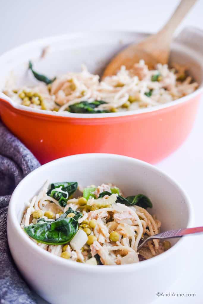 tuna noodle casserole in a white bowl with orange casserole dish in the background
