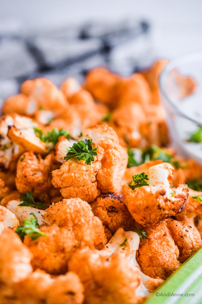 close up of air fryer buffalo cauliflower bites and bits of chopped parsley