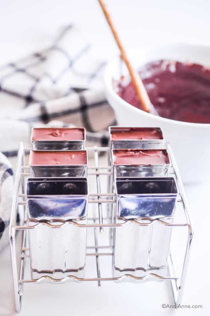 fudgesicle ingredients poured into steel popsicle moulds