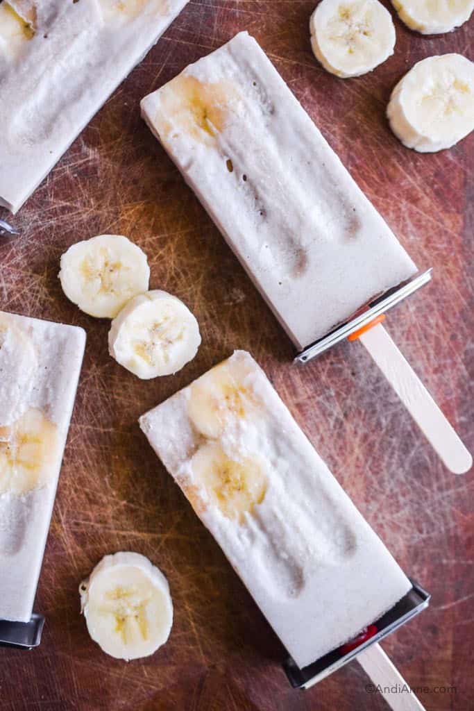 banana cream ice pops on wood cutting board with banana slices