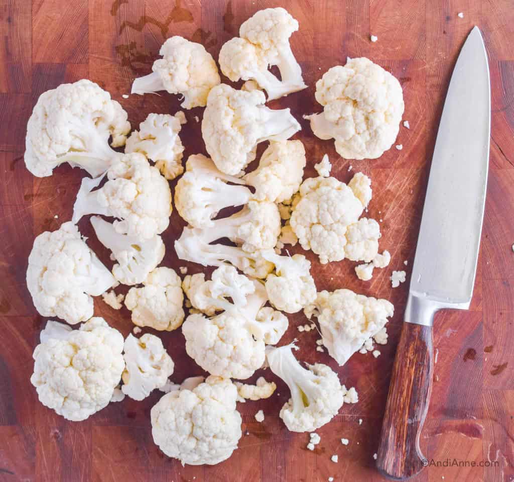 chopped cauliflower on a cutting board with a knife