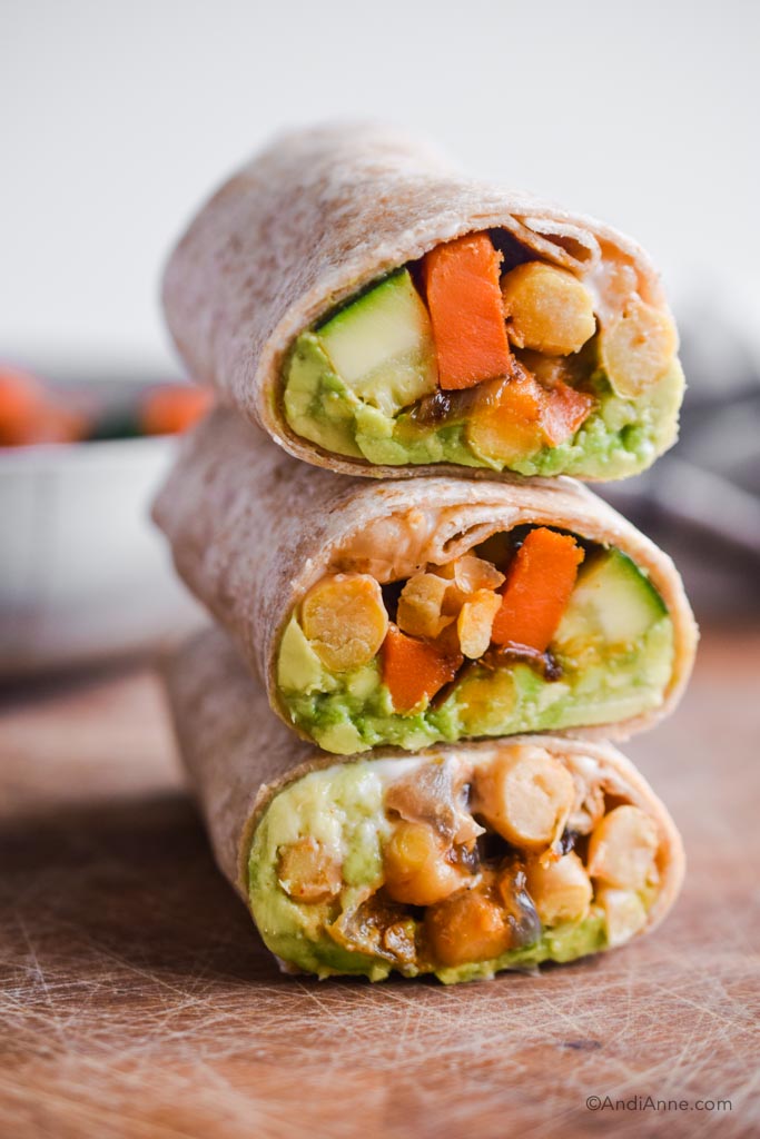 three chickpea zucchini stir fry wraps stacked on top of eachother.