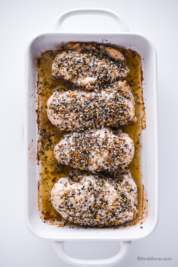 Everything bagel chicken breasts in a white casserole dish
