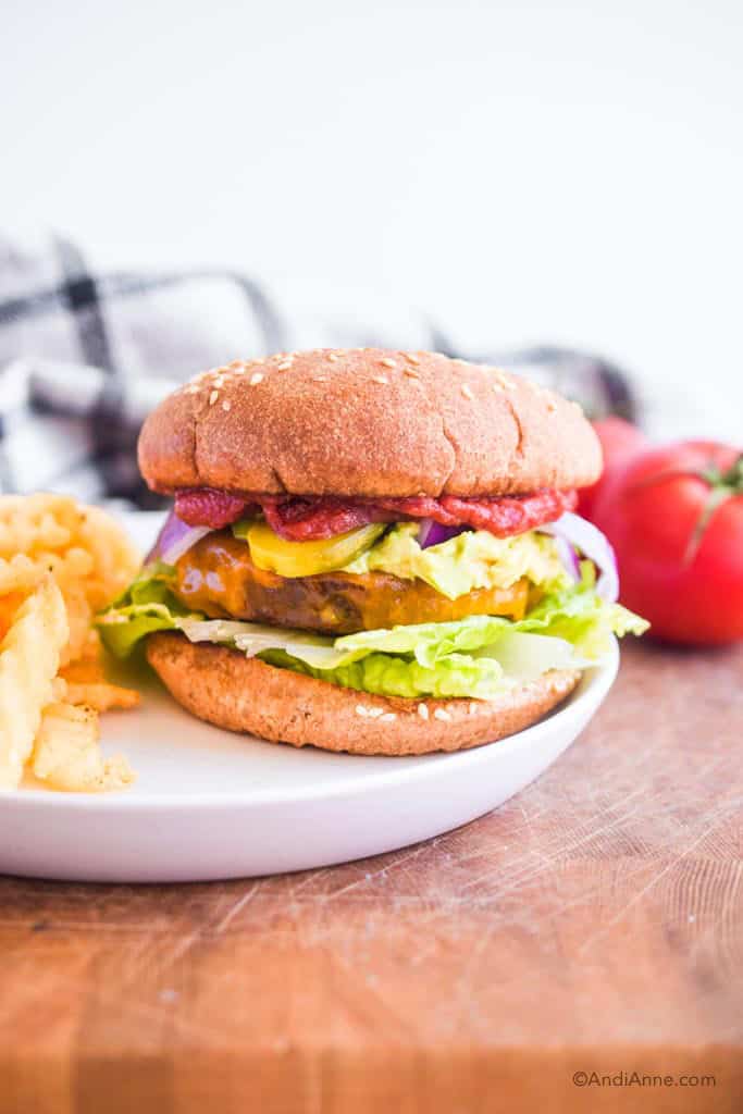 air fryer hamburgers on a white plate with fries and tomatoes on the side.