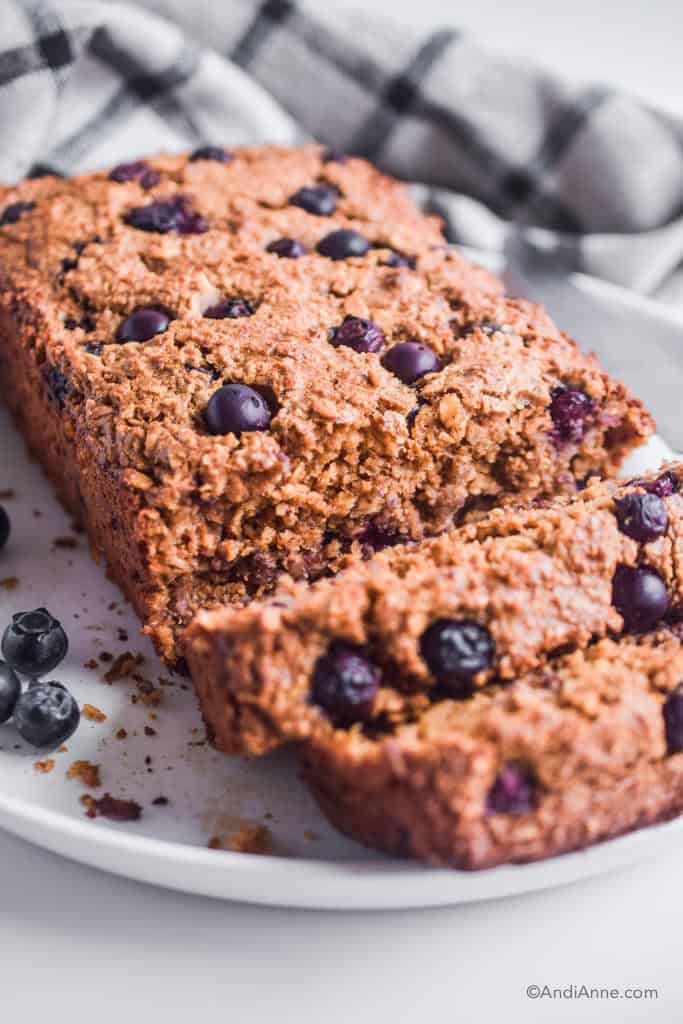 sliced blueberry breakfast loaf on a white plate.