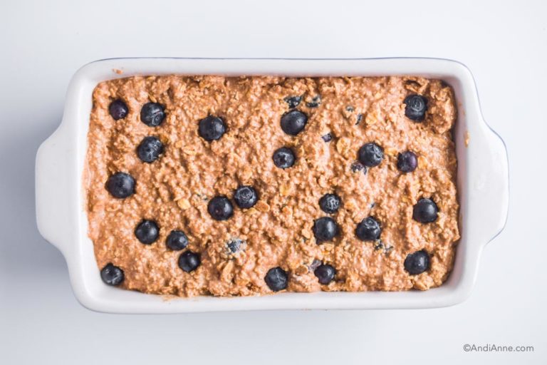 loaf batter with blueberries in a ceramic white loaf pan