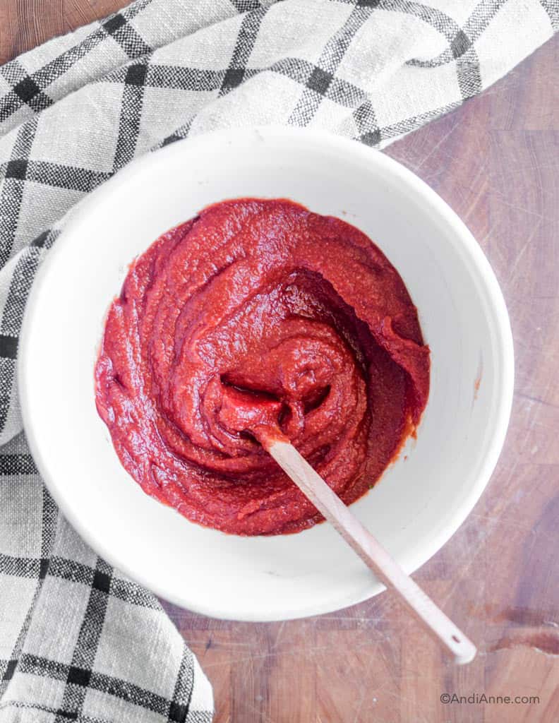 homemade ketchup in a white bowl with wooden spoon