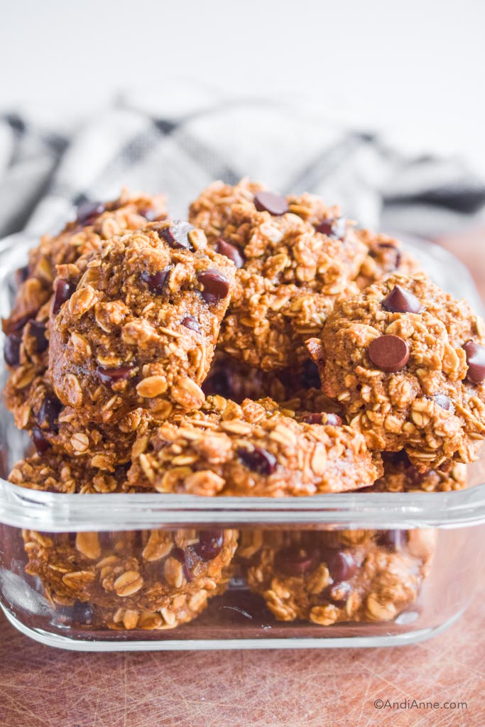 oatmeal chocolate chip cookies piled in a glass container 