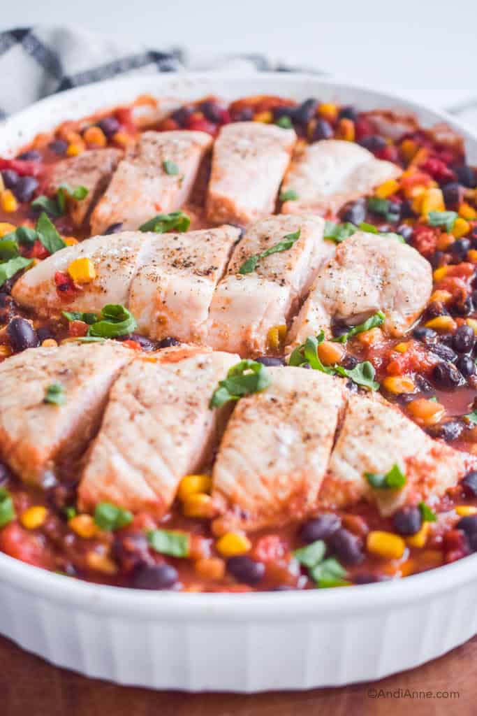 close up of dump and bake salsa chicken in a white baking dish.