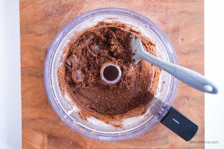 mixing chocolate chips into batter in food processor with grey spatula