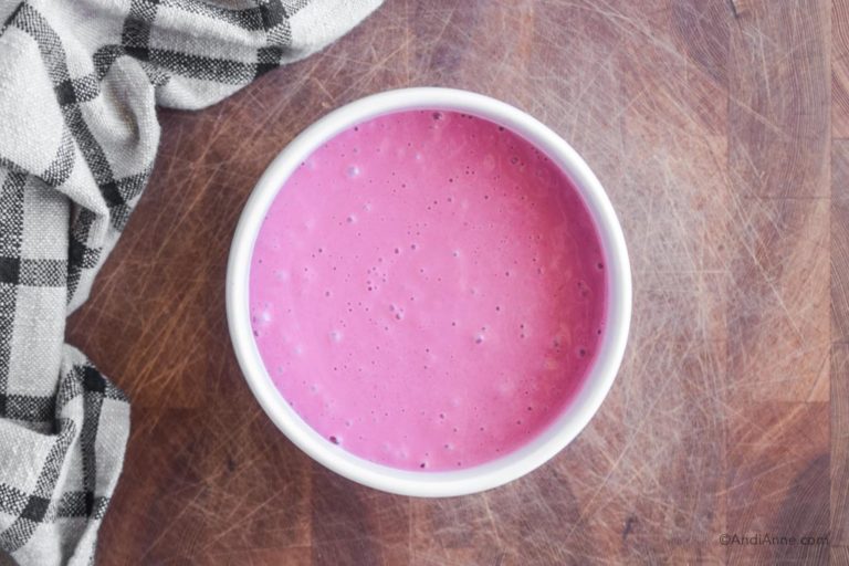 blended pink raspberry smoothie in a white bowl