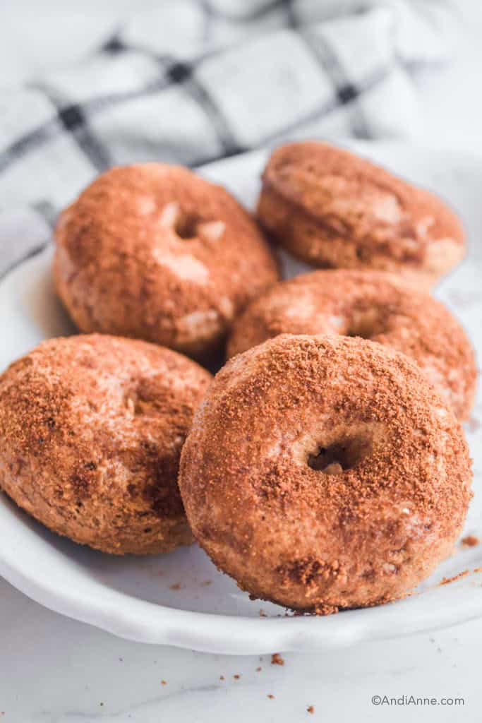 Stack of cinnamon sugar donuts in a white dish.