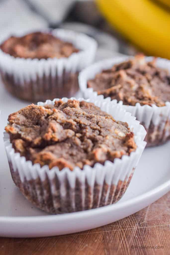 close up of coconut muffins in white paper cups on a white plate