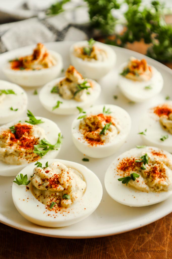 side angle of deviled eggs on plate sprinkled with chopped parsley