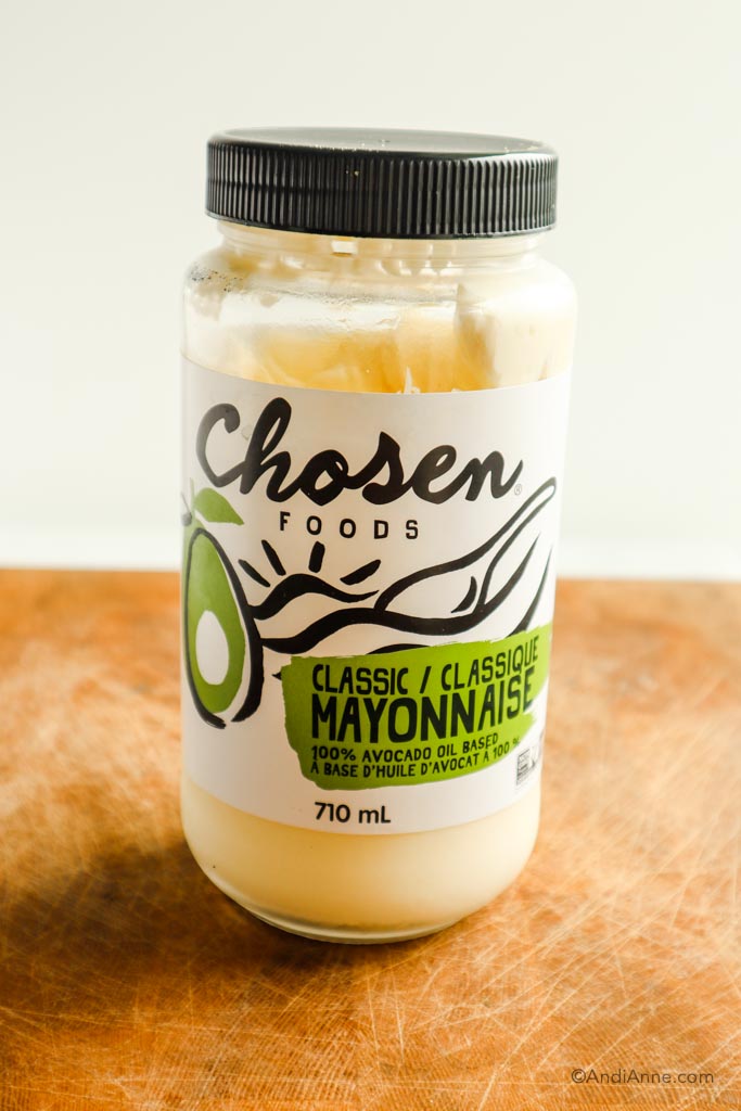 Jar of chosen foods classic mayonnaise on wood cutting board