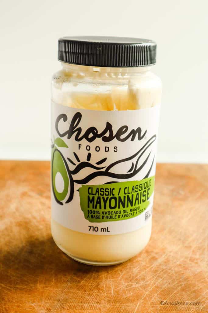 Jar of chosen foods classic mayonnaise on wood cutting board